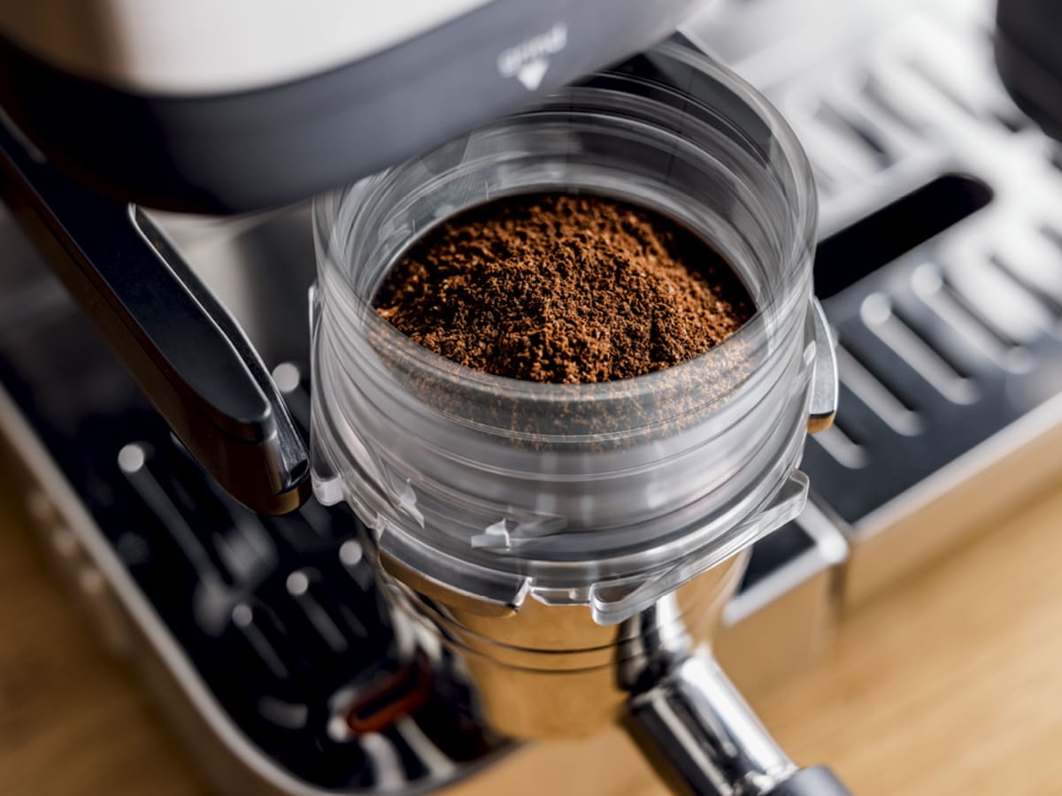 Built-in burr grinder dosing freshly ground coffee into portafilter